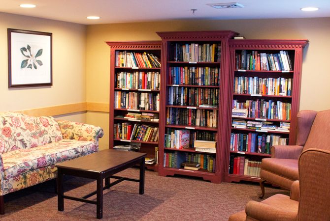 A cozy library corner with bookshelves filled with books and comfortable seating.