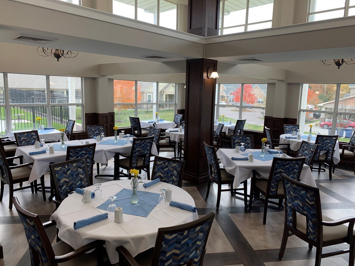 A spacious dining area with neatly arranged tables and chairs, featuring a well-lit interior design.