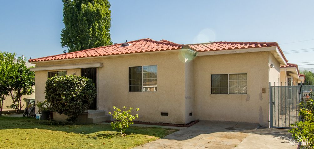 A single-story house with a red-tiled roof and a small front yard.