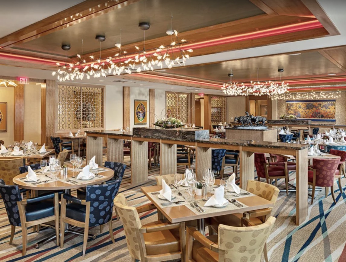 A spacious and elegantly decorated restaurant interior with neatly arranged tables and modern lighting.