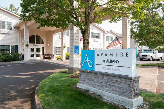 Entrance of Avamere at Albany with a prominently displayed sign and surrounding greenery.
