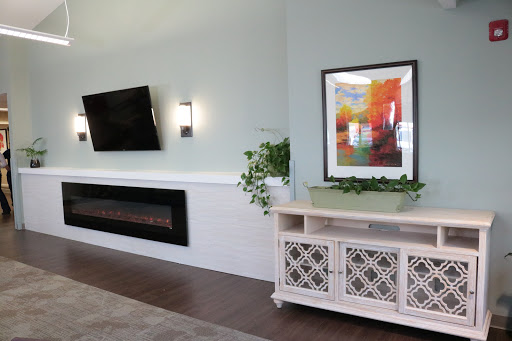 A modern living room featuring a sleek TV, a decorative fireplace, and vibrant artwork.
