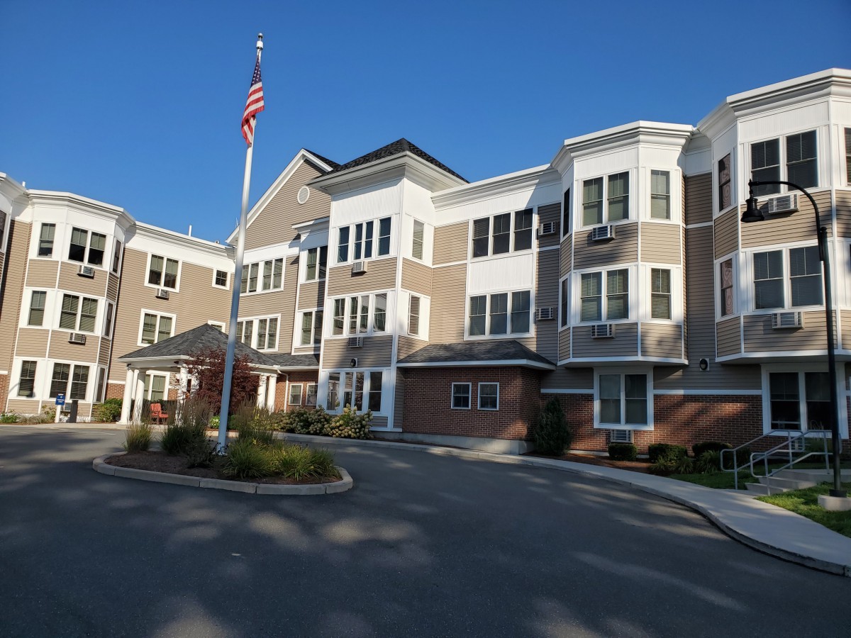A residential apartment building with an American flag in the foreground.