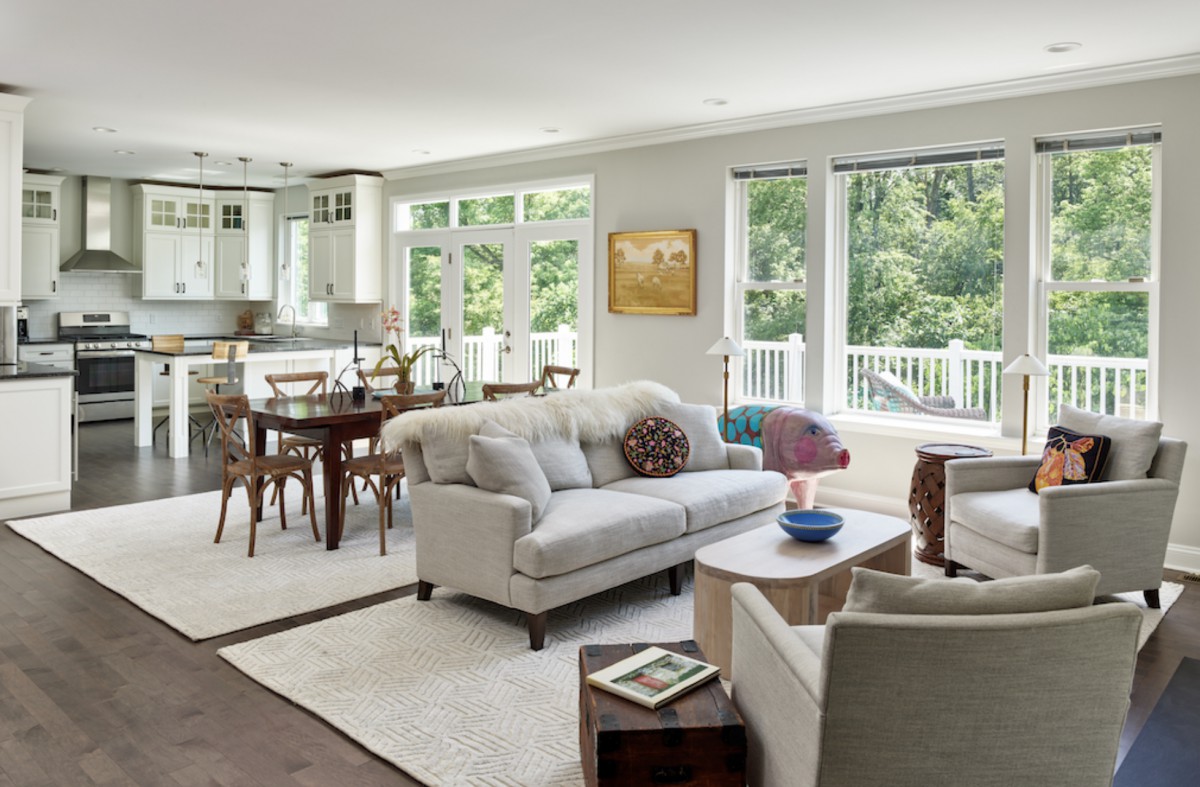A modern living and dining area featuring elegant furniture and large windows that let in natural light.