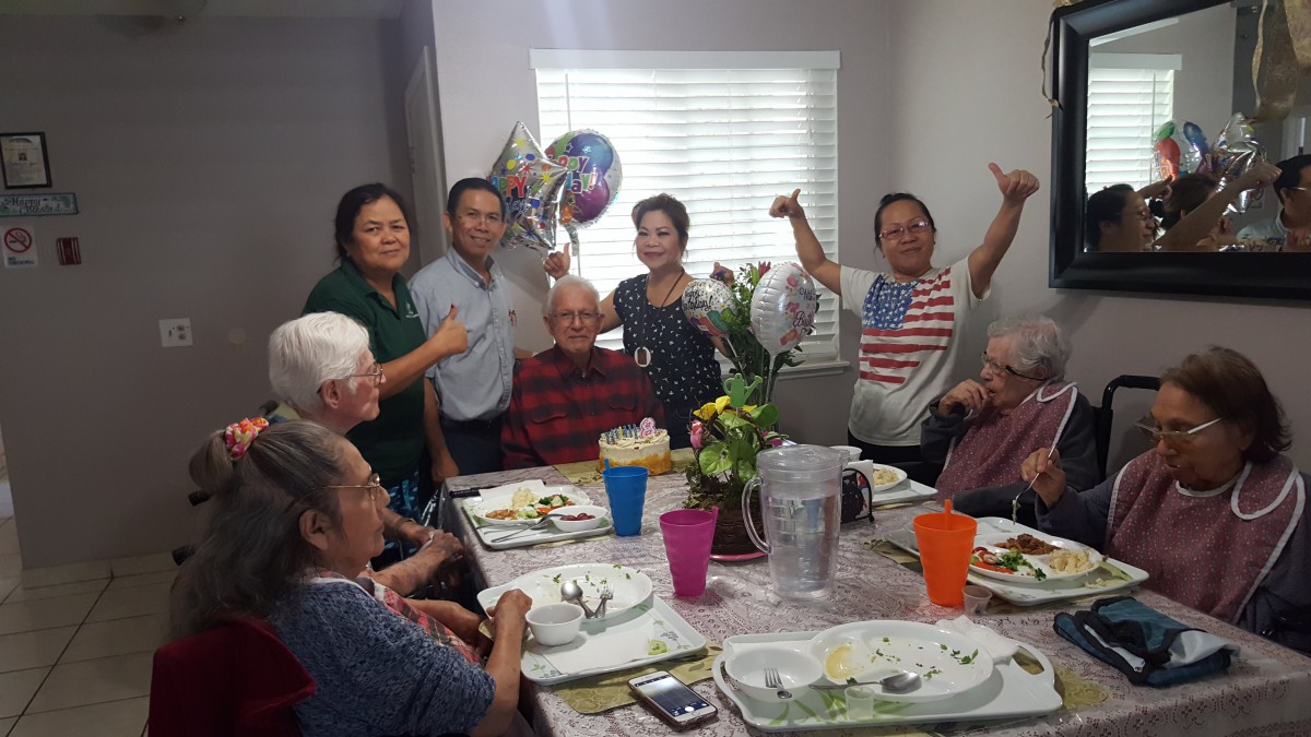 A joyful family gathering around a dining table celebrating together.
