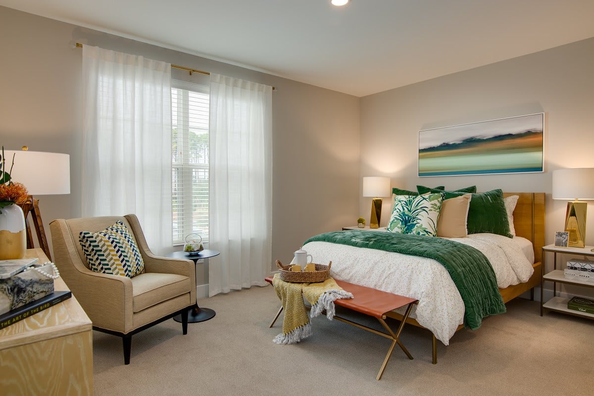 A modern bedroom with green accents and natural light.