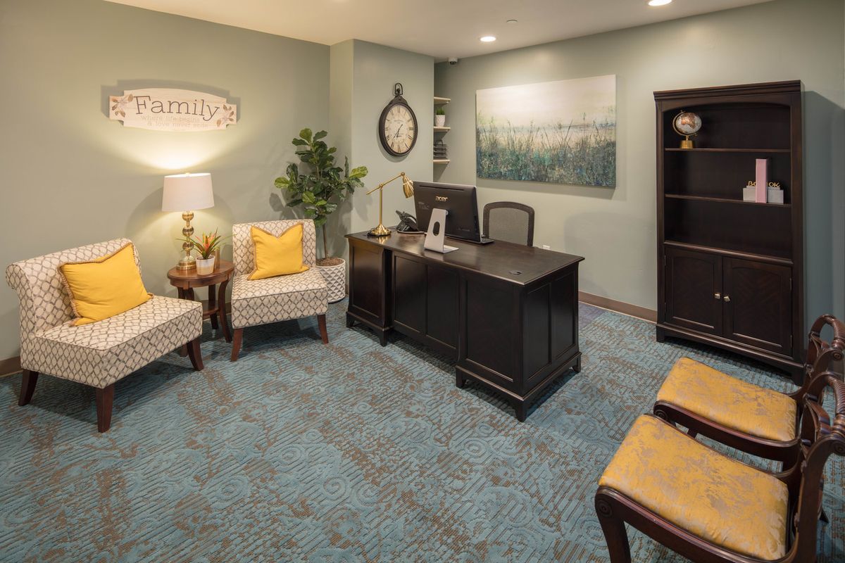 A cozy office setting with a desk, chairs, and decorative elements.