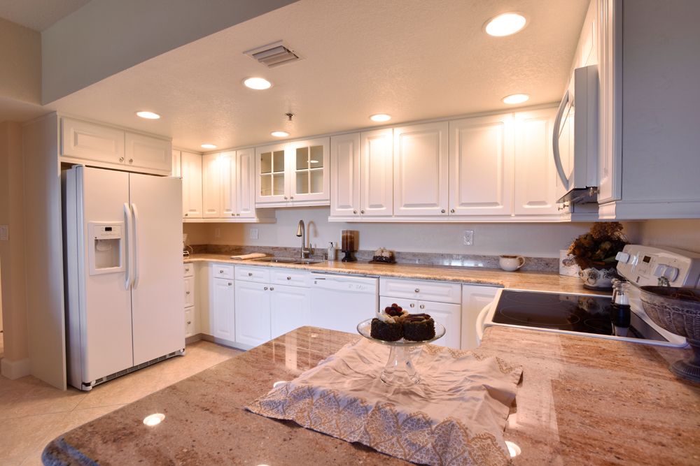 A modern kitchen with white cabinetry and a spacious countertop.