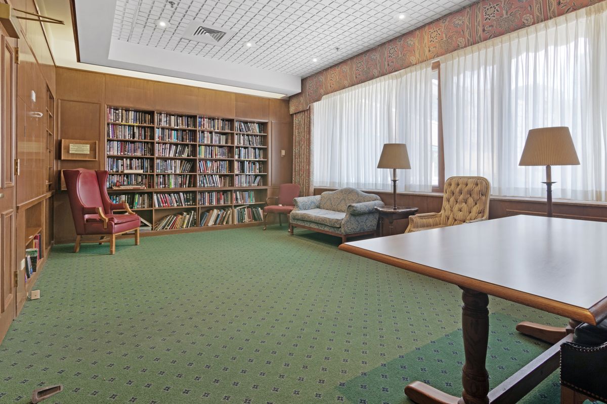 A cozy library room with bookshelves and comfortable furniture.