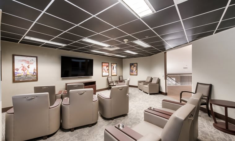 A modern lounge area with comfortable seating and a large TV.