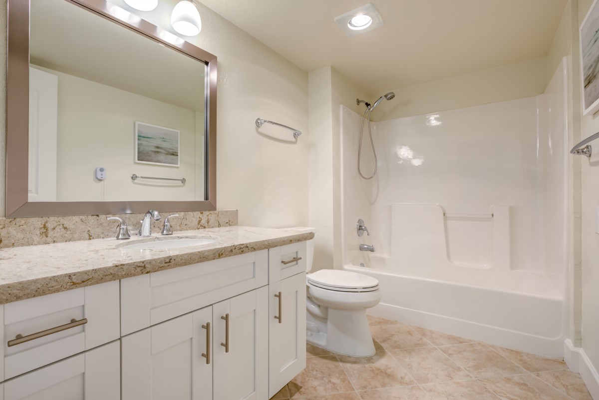 A clean and modern bathroom featuring a sink, toilet, and bathtub.