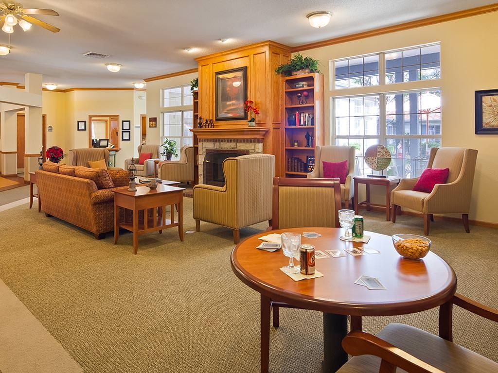 A cozy living room with a fireplace, comfortable seating, and a bookshelf.