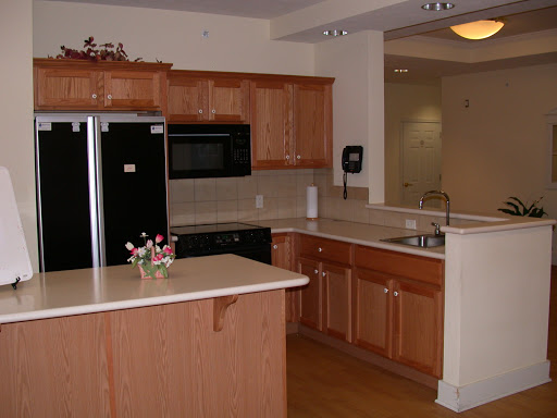 A modern kitchen featuring wooden cabinets and black appliances.
