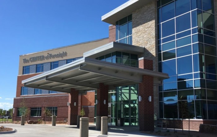 A modern hospital building with a glass entrance and architectural design.