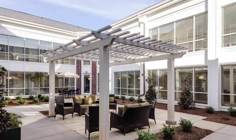 Outdoor seating area with a pergola and comfortable furniture.