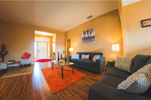 A cozy and modern living room featuring stylish sofas, a vibrant rug, and warm lighting.