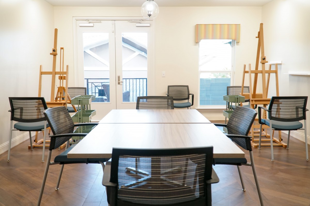 A bright and modern conference room with a large table and mesh chairs.