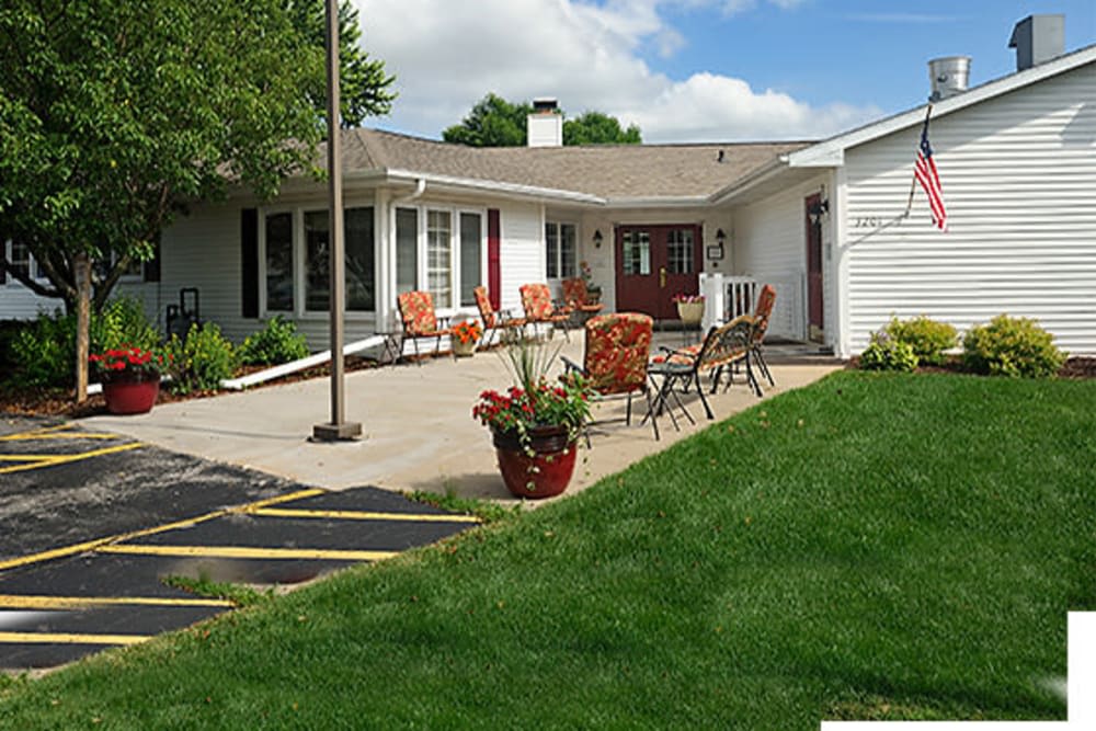 A cozy house with a furnished patio and lush green lawn.