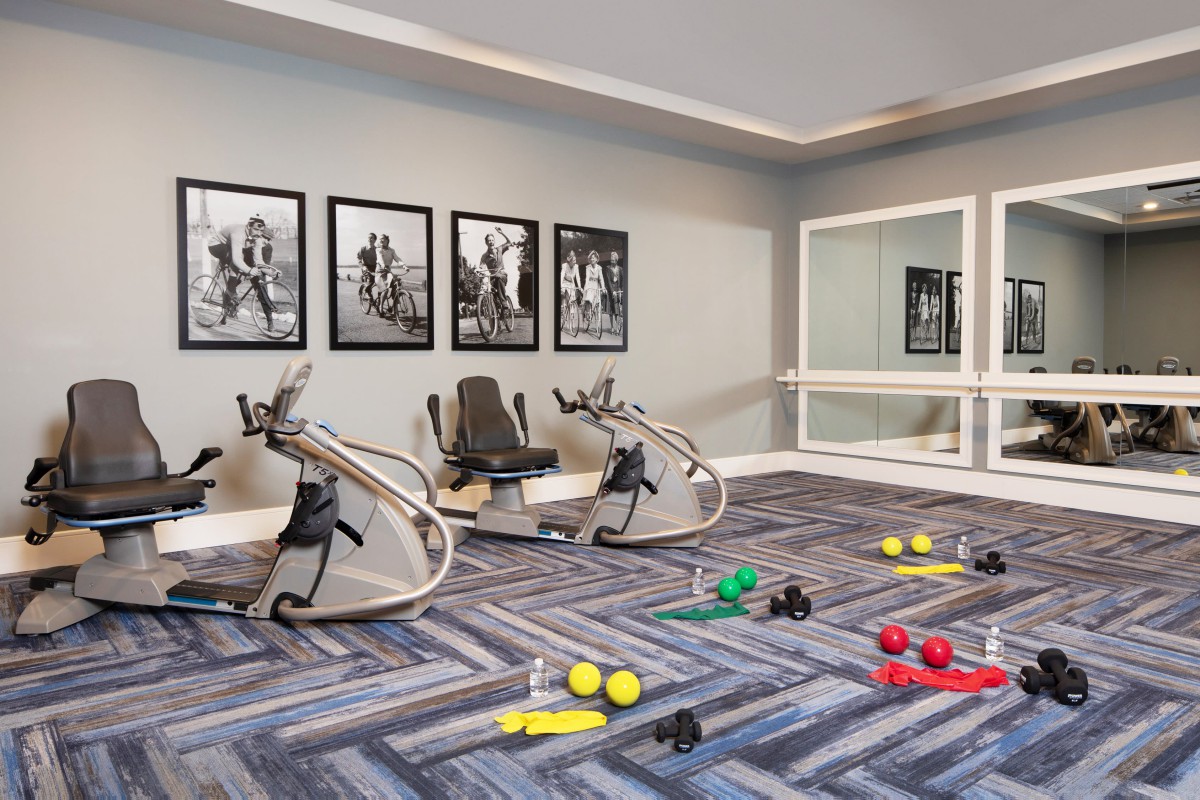 A modern fitness room with exercise machines and various colorful exercise balls.