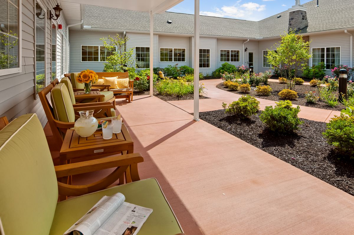 A peaceful patio area with comfortable seating, surrounded by a beautifully landscaped garden.