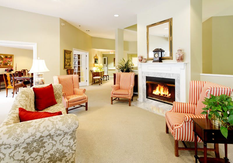 A cozy living room with a fireplace, traditional decor, and comfortable armchairs.