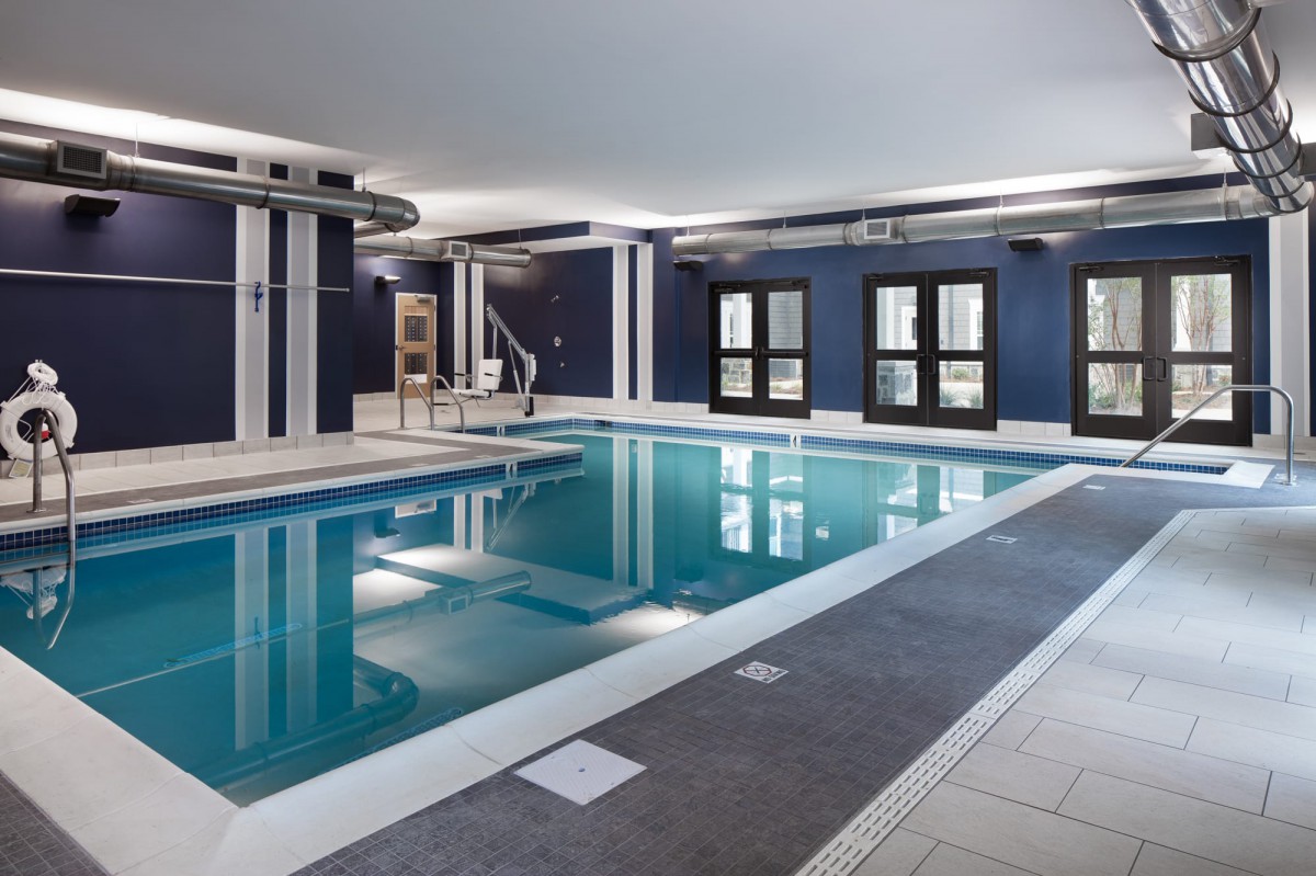 A modern indoor swimming pool with sleek design and large windows.