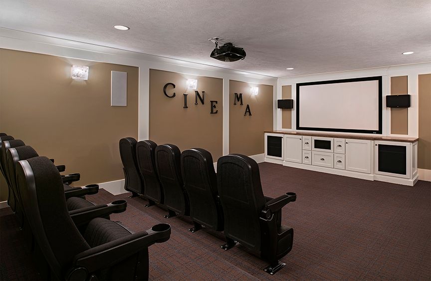 A cozy home theater room with seating and a large screen for movie viewing.