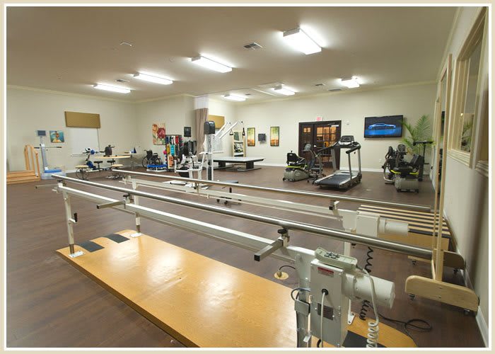 A spacious physical therapy clinic equipped with various rehabilitation and exercise machines.