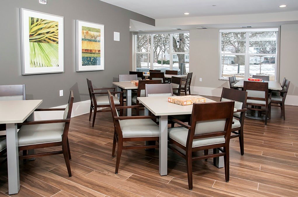 A modern dining area with wooden tables and chairs, adorned with artwork on the walls.