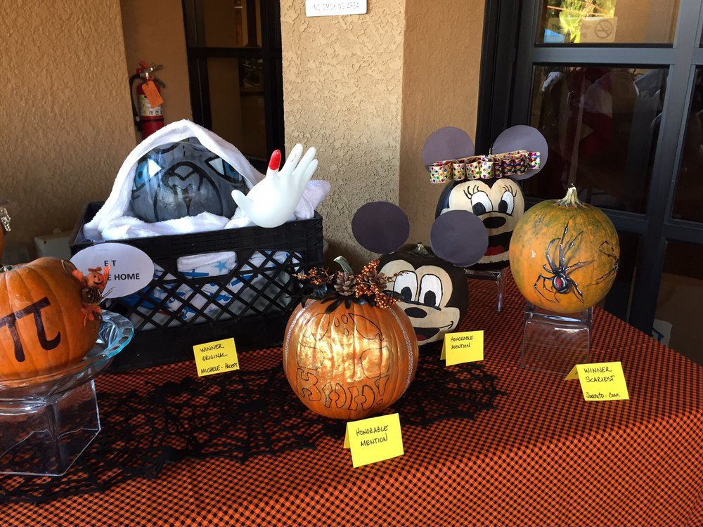 A festive Halloween display featuring creatively decorated pumpkins, including Mickey Mouse-themed designs.