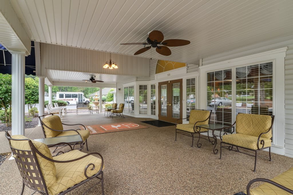 A spacious covered patio with comfortable seating and ceiling fans.