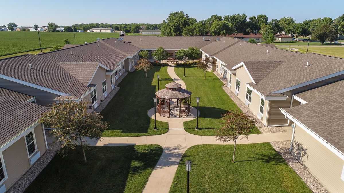 Aerial view of a residential building complex with a central courtyard featuring a gazebo and landscaped pathways.