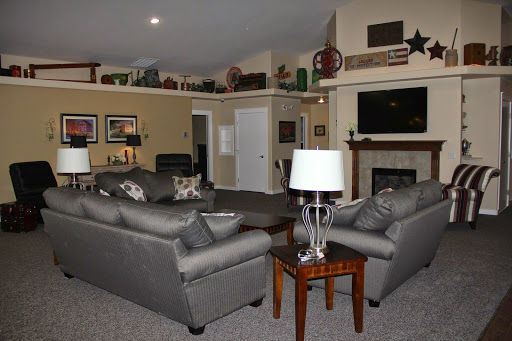 A cozy living room featuring comfortable sofas, a stylish lamp, and a warm fireplace.