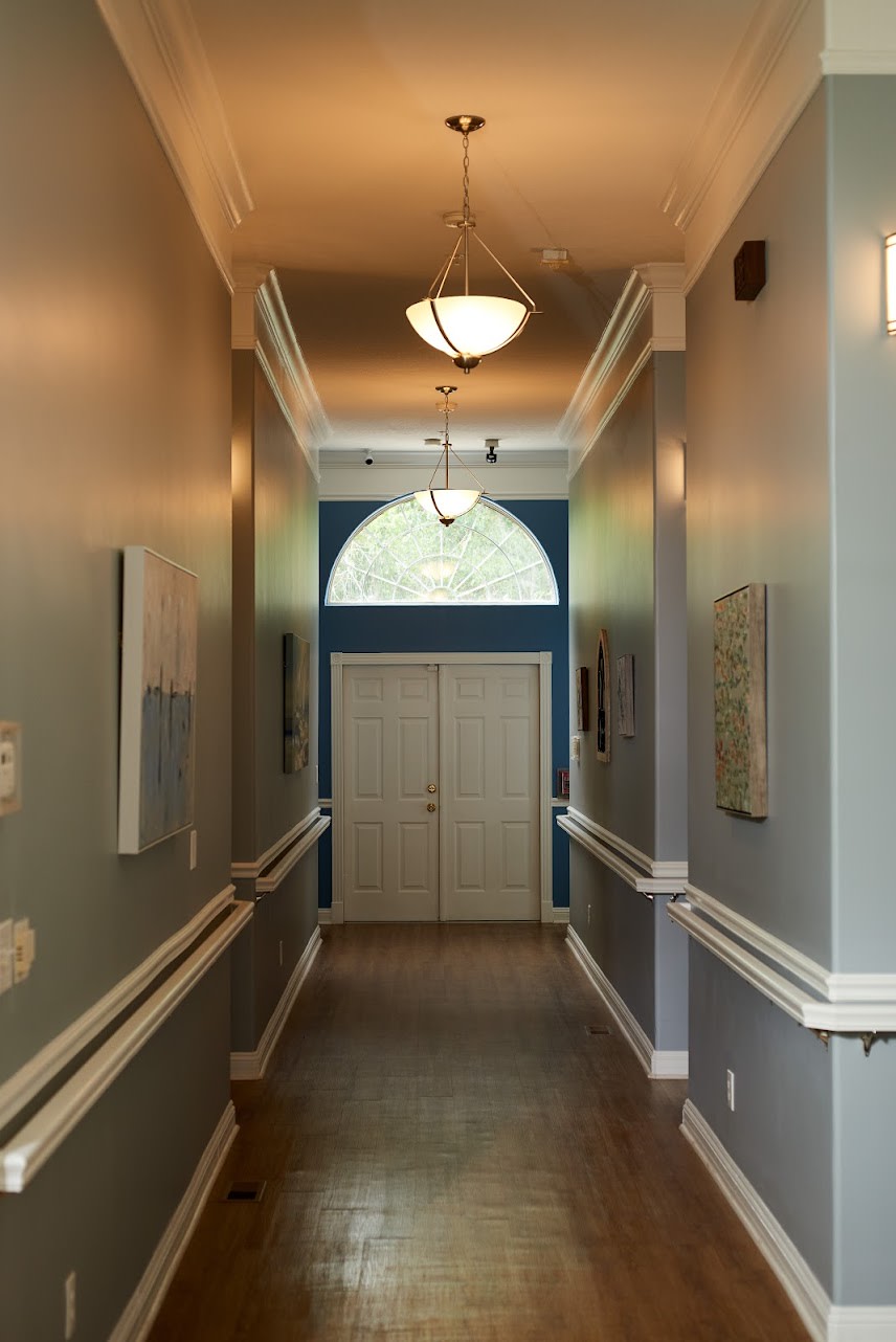 A well-lit hallway with closed double doors at the end.