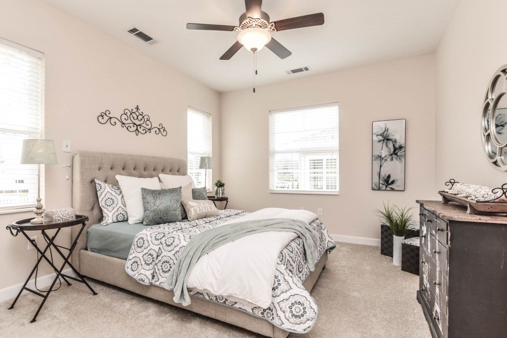 A modern and spacious bedroom featuring elegant decor in neutral tones.