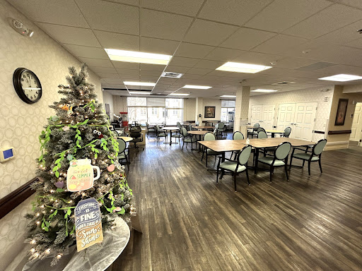 A spacious dining area featuring a beautifully decorated Christmas tree, ready for gatherings.