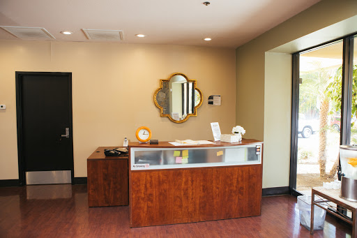 A view of a stylish reception area featuring a wooden desk and decorative mirror.