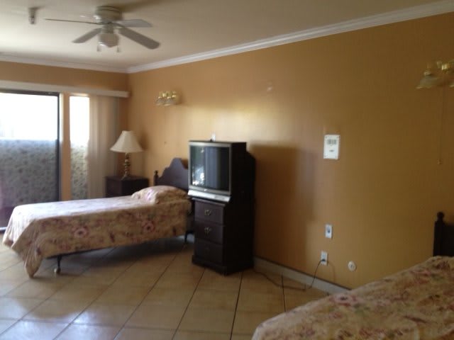 A hotel room with two beds, a television, and basic furnishings.