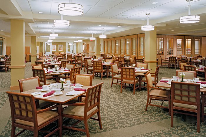 An empty dining room with neatly arranged tables and chairs.