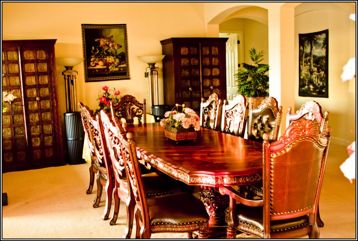 A beautifully decorated dining room featuring an ornate wooden table surrounded by matching chairs.