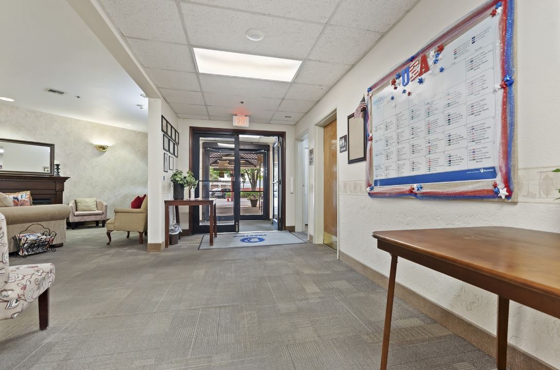 A spacious office hallway with an entrance door and a wall-mounted calendar.