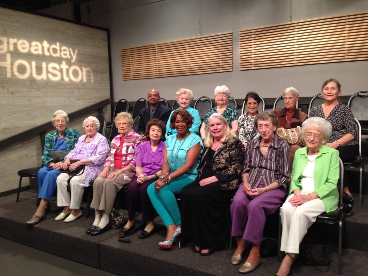 A group of seniors gathered in a studio setting, seated in rows.