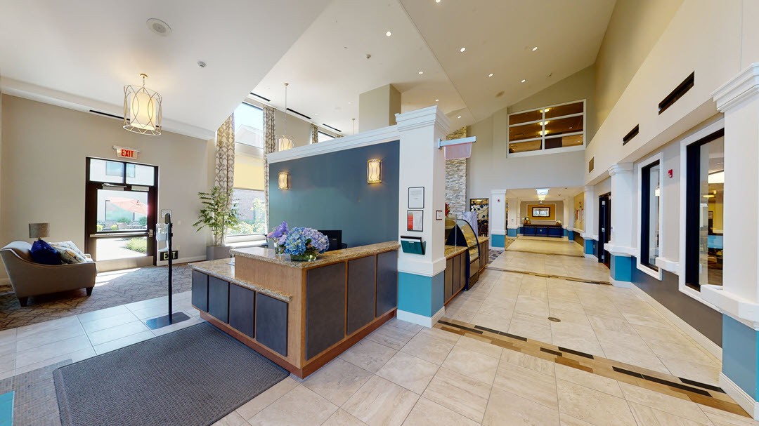 A modern hotel lobby with a reception desk and spacious interior.