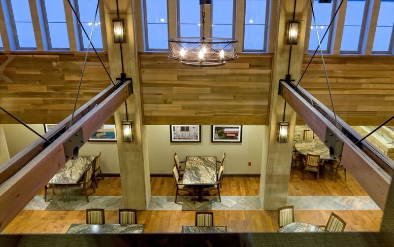 A modern dining area with a wooden ceiling and contemporary lighting.
