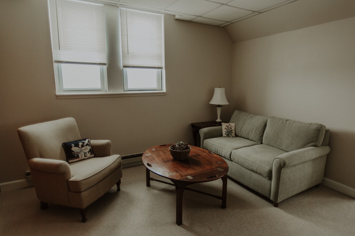 A cozy minimalist living room with a sofa, armchair, and coffee table.