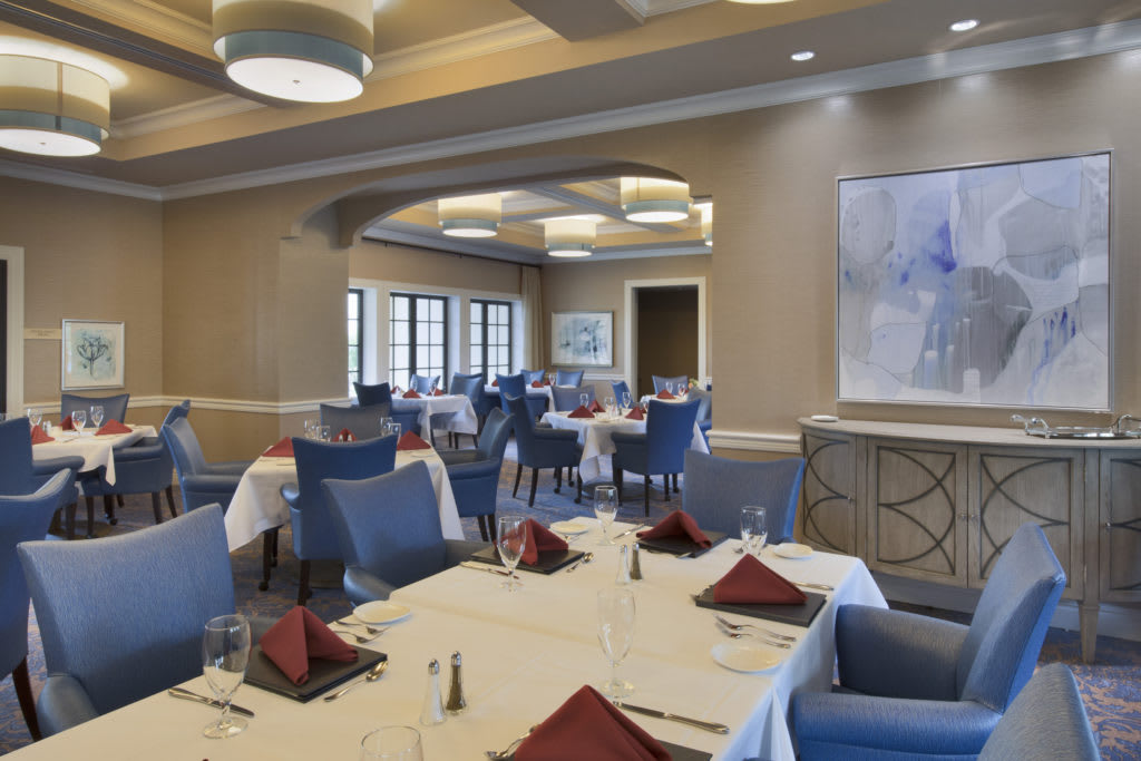 An elegant dining area with neatly arranged tables and chairs.