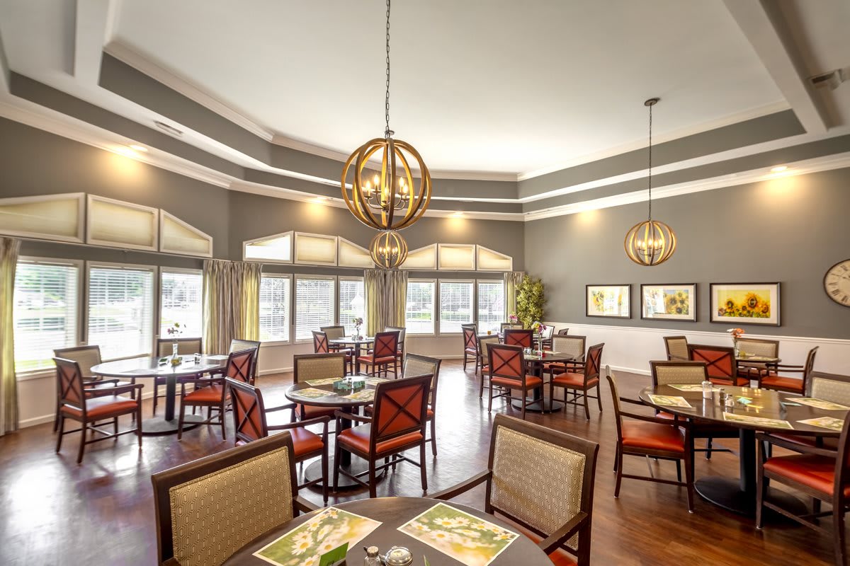 A spacious and well-lit restaurant dining area with neatly arranged tables and chairs.