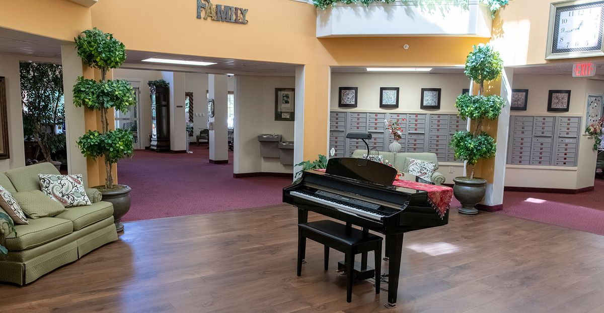 A piano situated in an inviting lobby area with warm lighting and framed artwork.