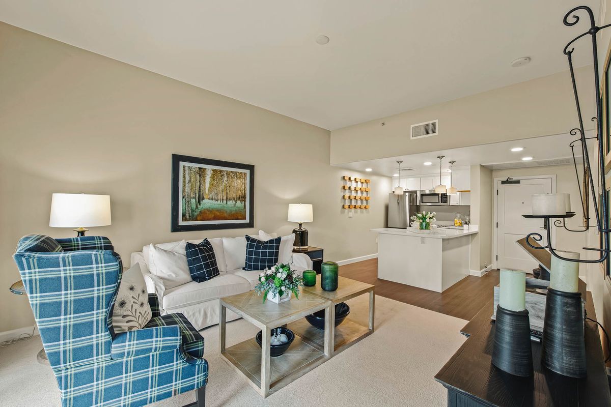 A modern apartment living room with an open concept layout featuring a neutral color scheme and stylish decor.