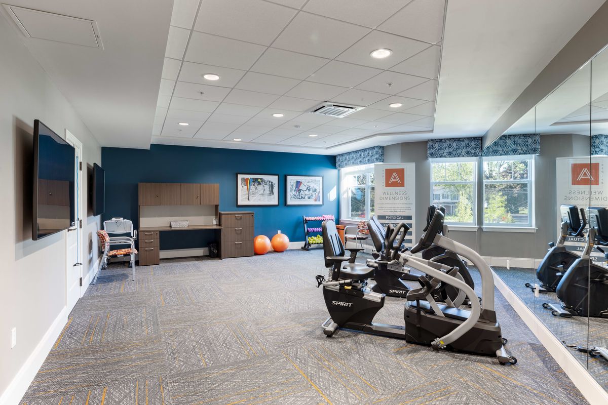 A modern fitness room with exercise equipment and bright decor.